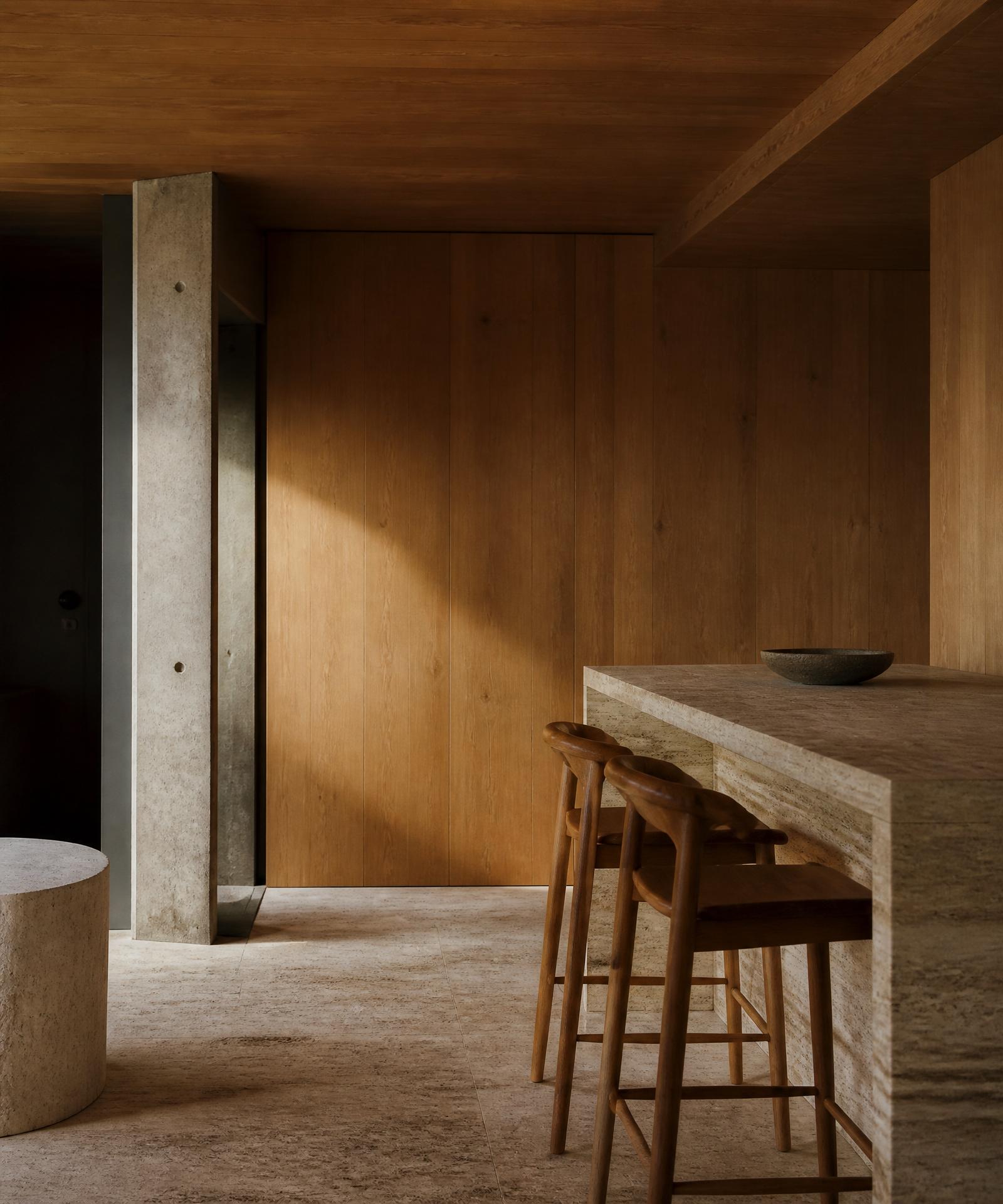 Warm oak and raw travertine meeting inside a quiet Swiss architectural interior